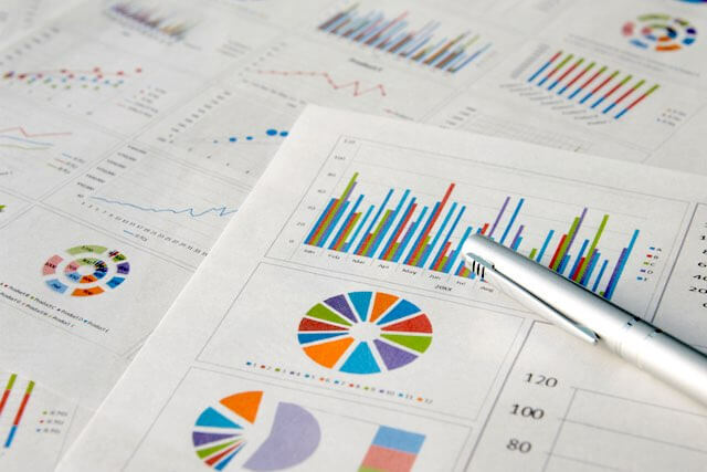 Pieces of paper spread out showing various financial data charts