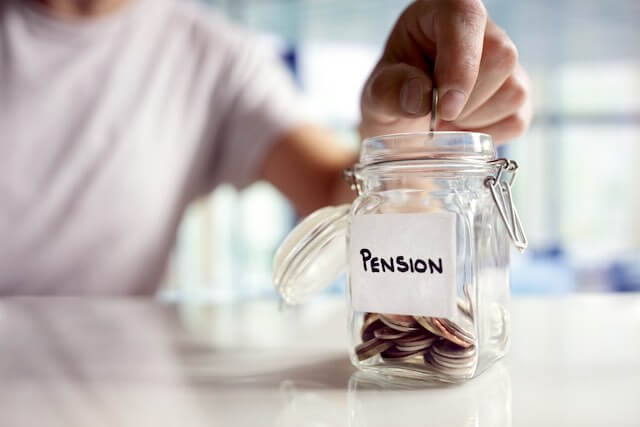 Person putting coins into a jar labeled 'pension' depicting annuity/retirement savings under FERS for federal employees