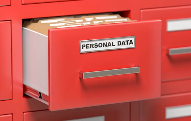 Red filing cabinet with a drawer partially opened that is labeled 'personal data'