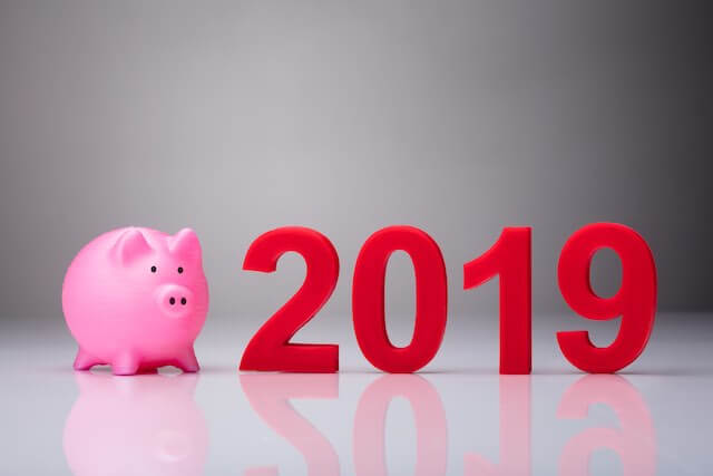 Pink piggy bank next to 3D numbers reading '2019' depicting a 2019 federal employee pay raise