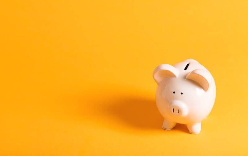 White piggy bank on a solid yellow background