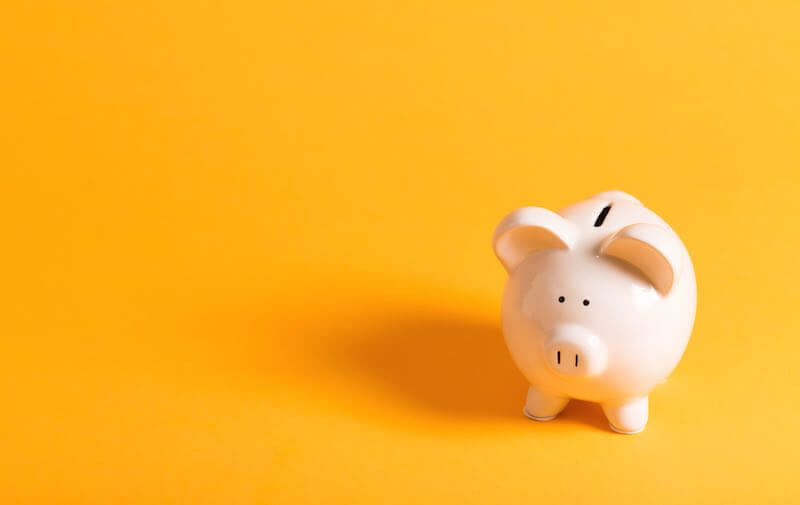 White piggy bank on a solid yellow background