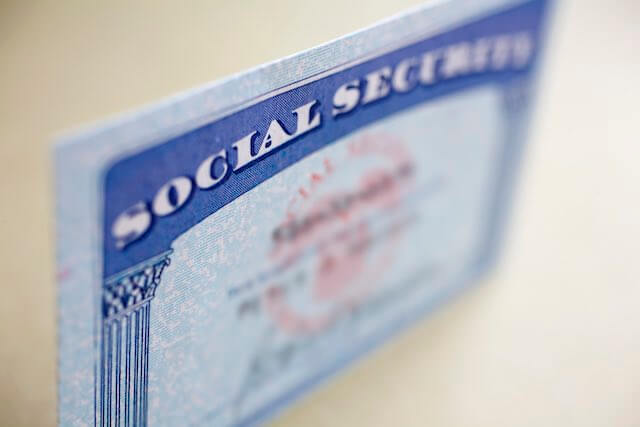 Social Security card against a solid beige background