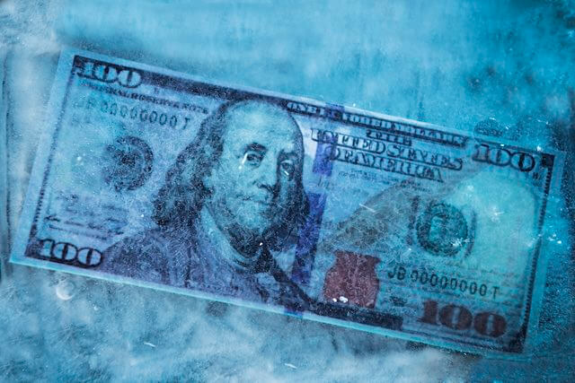 $100 bill frozen inside of a block of ice depicting pay freeze/no pay raise