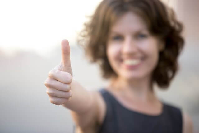 Woman smiling and giving a 'thumbs up'