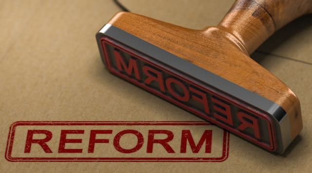 Rubber stamp imprinting the word 'reform' in red on paper