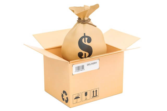 Cardboard shipping box with a bag full of cash denoted by a dollar sign ($) being placed inside of it