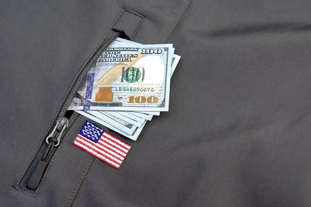 Close up of cash in the pocket of a military uniform - military benefits, pay
