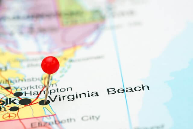 Pin stuck in a map on Virginia Beach, Virginia also showing surrounding locality pay area cities Norfolk and Hampton