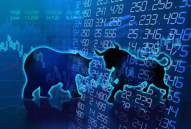 Silhouettes of a bull and a bear superimposed over stock charts depicting uncertainty of a bull or bear stock market returns