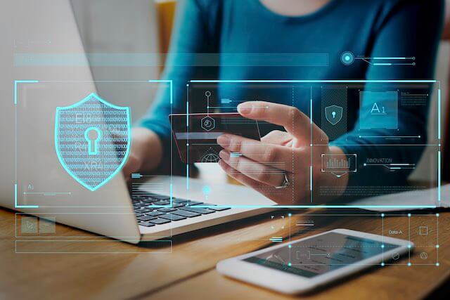 Woman using a credit card to shop online emblazoned with a security shield depicting identity theft protection