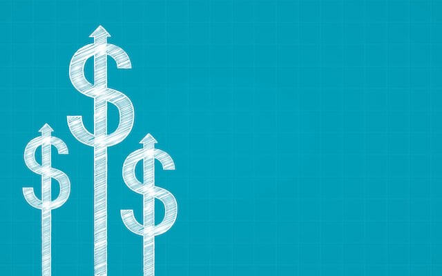 Three white dollar signs against a turquoise background at different heights depicting growth of money/investments