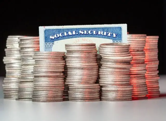 Stacks of silver coins surrounding a Social Security card, the top of which is just visible over the stacks of coins