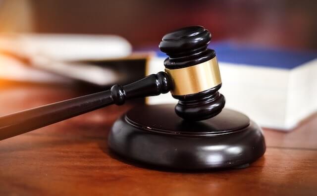 Judge's gavel on a desk with a law book