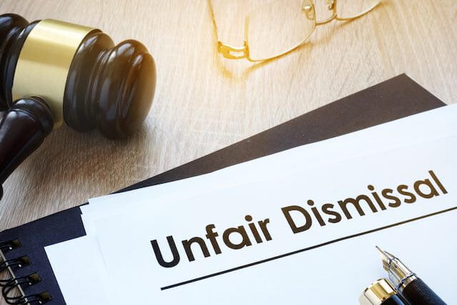 Judge's gavel on a desk next to a document labeled 'unfair dismissal'