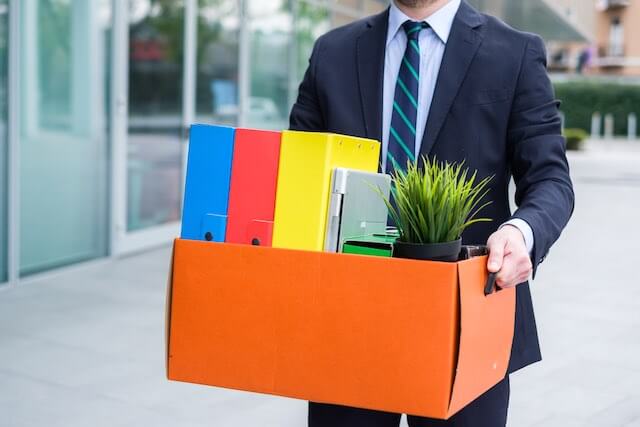 Businessman leaving his office after termination of employment