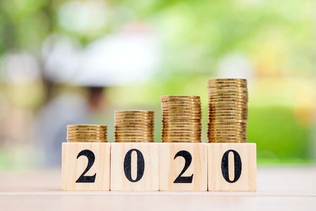 4 vertical stacks of coins growing in height from left to right with wooden blocks in front that read '2020' depicting a 2020 pay raise