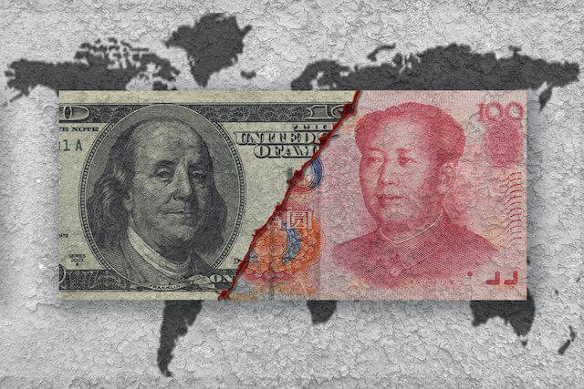 Currency note with the face of a $100 bill next to the Chinese yuan with a torn edge between the two overlaid on top of a world map