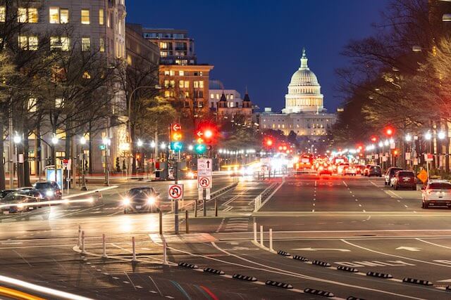 View of the capitol building in Washington, DC at night with the street lit up