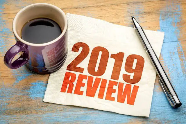napkin with the words '2019 review' pictured on it sitting on a wooden surface next to a coffee cup and a pen