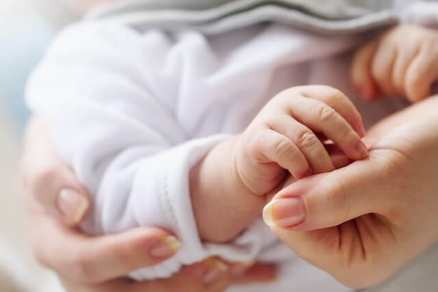 Close up of a mother holding her baby's hand