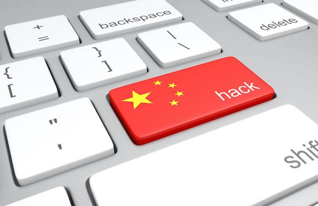Red key on a computer keyboard with a Chinese flag on it and the word 'hack' written on it