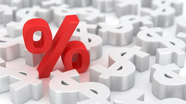 A single red 3D percent sign among a series of 3D white dollar signs around it
