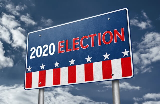 Road sign against a sky background that reads '2020 election' in American flag design/colors