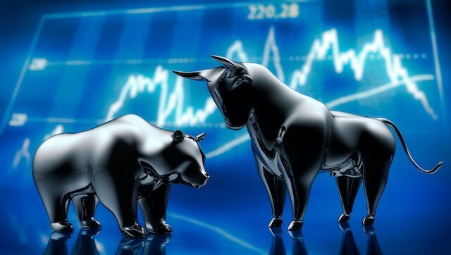 Illustration of a bear and a bull overlaid on a stock market graph