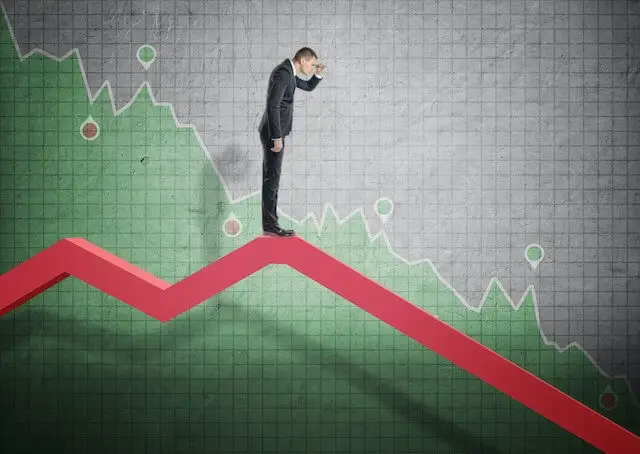 Businessman standing on a falling financial chart as he looks off to the right towards the future