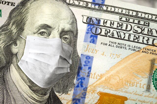Close up of Benjamin Franklin's picture on the $100 bill seen wearing a surgical mask