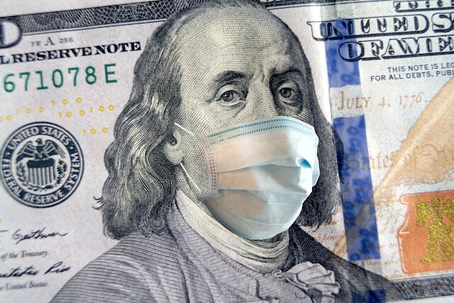 Close up of the face of Benjamin Franklin on a $100 bill wearing a face mask to protect from the COVID-19 coronavirus