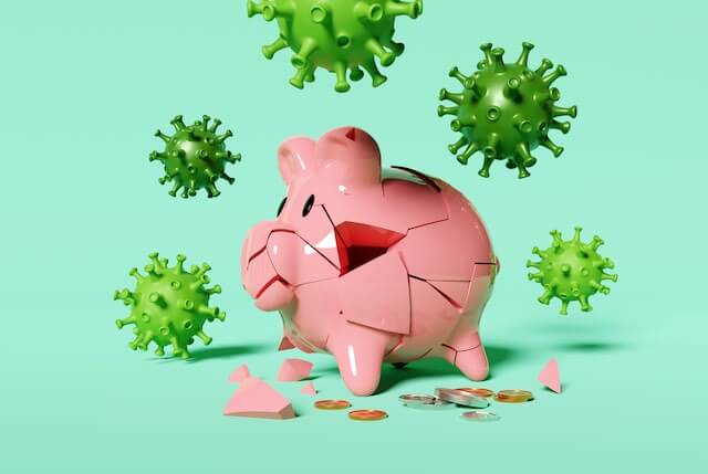 COVID-19 coronavirus cells surrounding a broken piggy bank