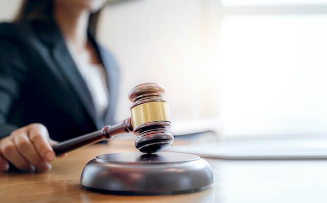 Female judge sitting at a desk holding a wooden gavel