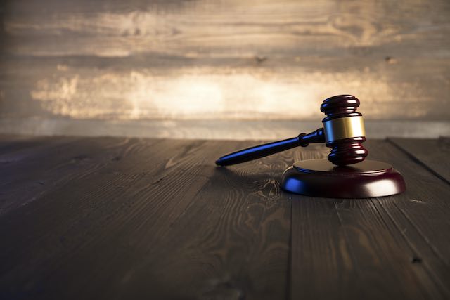 Wooden judge's gavel sitting on a wooden surface