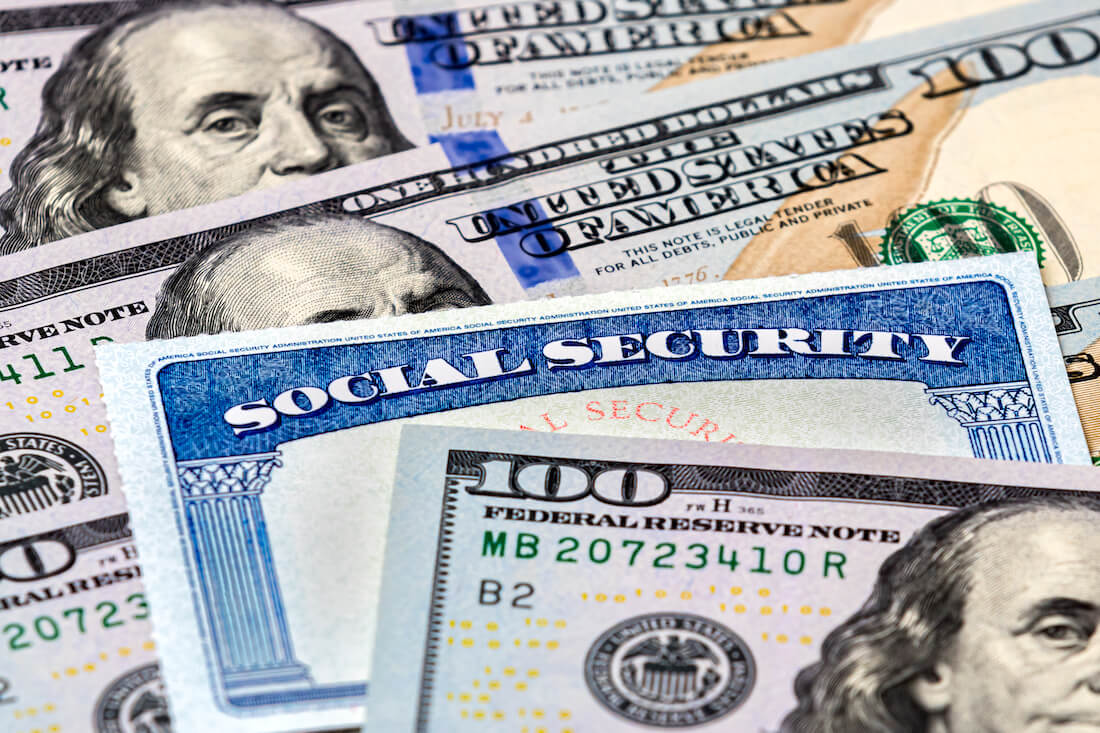 $100 bills (cash) in a spread with a Social Security card