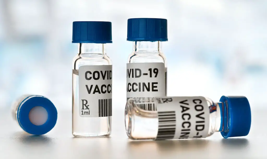 Four vials labeled 'COVID-19 vaccine'