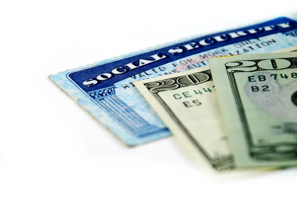 Social Security card with cash (two $20 bills) against a solid white background