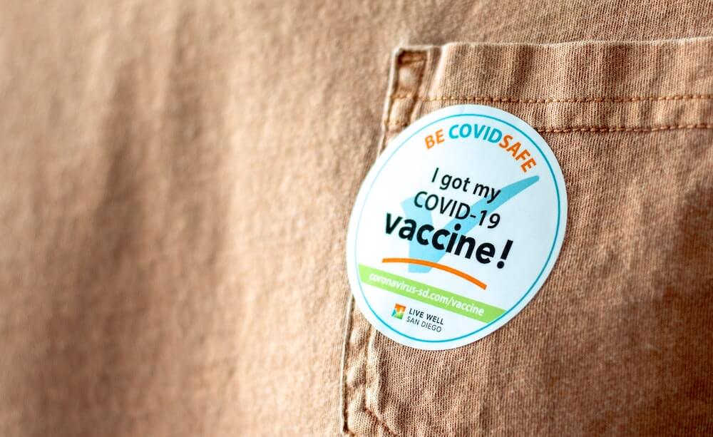 Sticker stuck to a t-shirt pocket that reads 'I got my COVID-19 vaccine!'