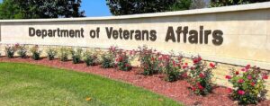 wall reading "Department of Veterans Affairs" lined with rose bushes outside of the Jacksonville National Cemetery