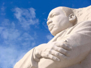 Close up of the face of the Martin Luther King, Jr. (MLK) memorial in Washington, DC against a blue sky background