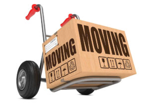 Cardboard moving box on a dolly against a white background