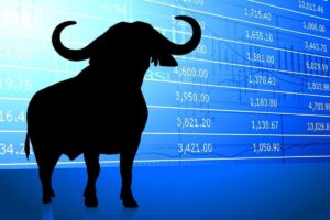 Silhouette of a bull overlaid on a table of stock market prices against a blue background