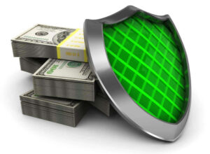 Green plated shield in front of a stack of cash on a white background