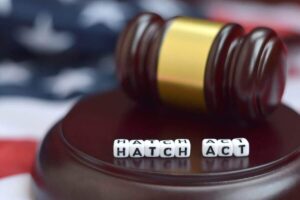 Judge's gavel with the words 'hatch act' spelled in block letters sitting on top of the gavel stand