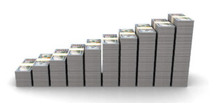 Stacks of cash growing in size from left to right against a white background