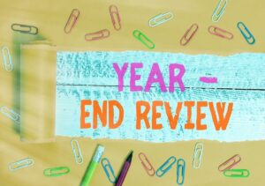 Words 'year in review' written in a torn edge design surrounded by paperclips