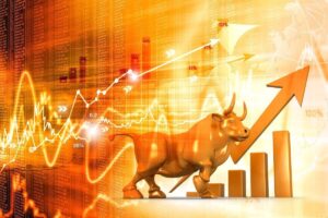 Golden colored bull next to a rising arrow and bar graph overlaid on top of a gold colored background with financial charts