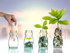 Row of jars with growing numbers of coins in each from left to right; the far right jar has a green plant growing out of it