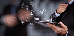 close up of businessman holding a tablet with digital process icons overlaid on the image